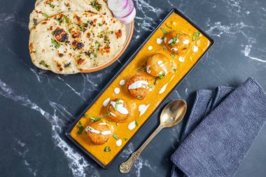 Zengin, baharatlı kaju soslu, yumuşak, kremalı malai kofta, sıcak, kabarık tereyağlı ve aromalı Kuzey Hindistan lezzeti ile mükemmel eşleştirilmiş..