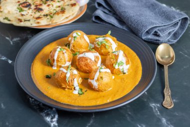 Zengin, baharatlı kaju soslu, yumuşak, kremalı malai kofta, sıcak, kabarık tereyağlı ve aromalı Kuzey Hindistan lezzeti ile mükemmel eşleştirilmiş..