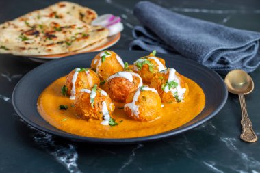 Zengin, baharatlı kaju soslu, yumuşak, kremalı malai kofta, sıcak, kabarık tereyağlı ve aromalı Kuzey Hindistan lezzeti ile mükemmel eşleştirilmiş..