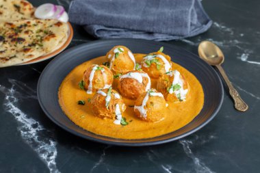 Zengin, baharatlı kaju soslu, yumuşak, kremalı malai kofta, sıcak, kabarık tereyağlı ve aromalı Kuzey Hindistan lezzeti ile mükemmel eşleştirilmiş..