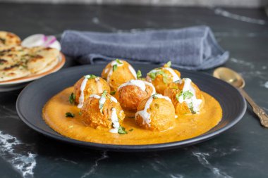 Zengin, baharatlı kaju soslu, yumuşak, kremalı malai kofta, sıcak, kabarık tereyağlı ve aromalı Kuzey Hindistan lezzeti ile mükemmel eşleştirilmiş..