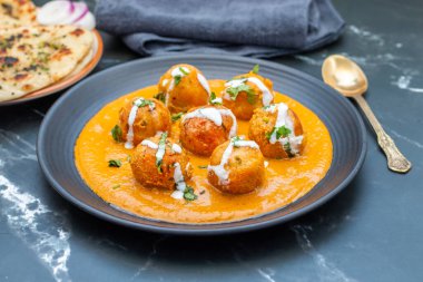 Zengin, baharatlı kaju soslu, yumuşak, kremalı malai kofta, sıcak, kabarık tereyağlı ve aromalı Kuzey Hindistan lezzeti ile mükemmel eşleştirilmiş..