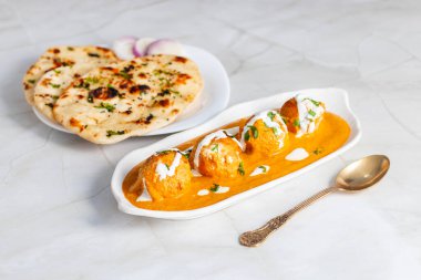 Zengin, baharatlı kaju soslu, yumuşak, kremalı malai kofta, sıcak, kabarık tereyağlı ve aromalı Kuzey Hindistan lezzeti ile mükemmel eşleştirilmiş..
