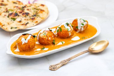 Zengin, baharatlı kaju soslu, yumuşak, kremalı malai kofta, sıcak, kabarık tereyağlı ve aromalı Kuzey Hindistan lezzeti ile mükemmel eşleştirilmiş..
