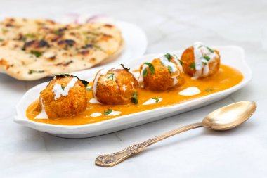 Zengin, baharatlı kaju soslu, yumuşak, kremalı malai kofta, sıcak, kabarık tereyağlı ve aromalı Kuzey Hindistan lezzeti ile mükemmel eşleştirilmiş..
