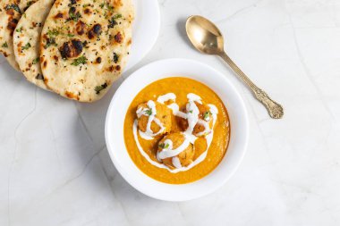 Zengin, baharatlı kaju soslu, yumuşak, kremalı malai kofta, sıcak, kabarık tereyağlı ve aromalı Kuzey Hindistan lezzeti ile mükemmel eşleştirilmiş..