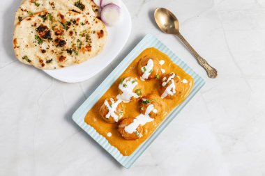 Zengin, baharatlı kaju soslu, yumuşak, kremalı malai kofta, sıcak, kabarık tereyağlı ve aromalı Kuzey Hindistan lezzeti ile mükemmel eşleştirilmiş..