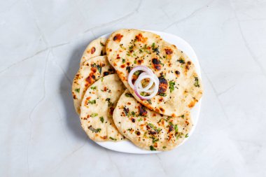 Tereyağlı naan, erimiş tereyağıyla fırçalanmış yumuşak, mayalanmış Hint ekmeğidir, zengin köri ve yahni ile eşleşmek için mükemmeldir..