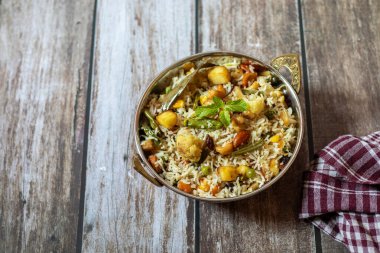 Navratan Pulao karışık sebzeler, kuru meyveler ve aromatik baharatlarla pişirilmiş kokulu, renkli bir pirinç tabağıdır..