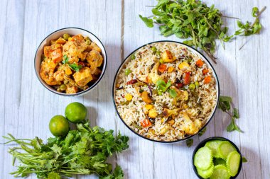 Aromatik Navratan Pulao: Kokulu Basmati pilavı, renkli sebzeler, Çıtır Fındık, Tatlı Ananas ve Zengin Baharat Kraliyet Karışımı, salatalık salatasıyla servis ediliyor