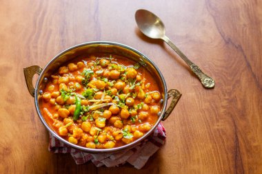 Kabuli Chana Masala, zengin ve sağlıklı bir kıvamda kaynatılmış nohut, domates, soğan ve aromatik baharatlarla yapılan lezzetli bir Kuzey Hint körisidir..