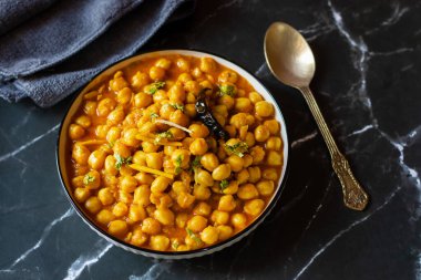 Kabuli Chana Masala, zengin ve sağlıklı bir kıvamda kaynatılmış nohut, domates, soğan ve aromatik baharatlarla yapılan lezzetli bir Kuzey Hint körisidir..