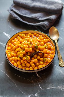 Kabuli Chana Masala, zengin ve sağlıklı bir kıvamda kaynatılmış nohut, domates, soğan ve aromatik baharatlarla yapılan lezzetli bir Kuzey Hint körisidir..
