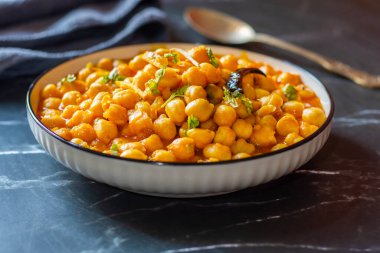 Kabuli Chana Masala, zengin ve sağlıklı bir kıvamda kaynatılmış nohut, domates, soğan ve aromatik baharatlarla yapılan lezzetli bir Kuzey Hint körisidir..