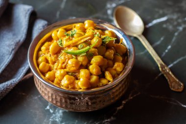 Kabuli Chana Masala, zengin ve sağlıklı bir kıvamda kaynatılmış nohut, domates, soğan ve aromatik baharatlarla yapılan lezzetli bir Kuzey Hint körisidir..