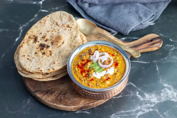 Dal Makhani, zengin ve kremalı bir mercimek köri, dumanlı, kömürleşmiş tandır, rotian düşkünü Kuzey Hindistan mutfağı lezzeti ile mükemmel gider..