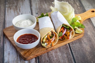 Tavuk shawarma dürümü baharatlı ızgara tavuk, sarımsak sosu, sebze turşusu ve taze ekmek ile yapılan bir Orta Doğu dürümü..