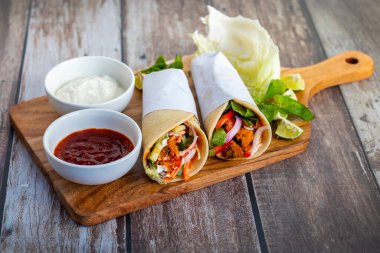 Tavuk shawarma dürümü baharatlı ızgara tavuk, sarımsak sosu, sebze turşusu ve taze ekmek ile yapılan bir Orta Doğu dürümü..