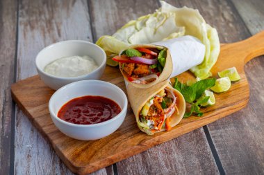 Tavuk shawarma dürümü baharatlı ızgara tavuk, sarımsak sosu, sebze turşusu ve taze ekmek ile yapılan bir Orta Doğu dürümü..