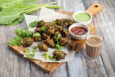 Palak ke pakore gevrek, bol yağda kızartılmış ıspanaklı börek besan, baharat ve taze ıspanak yapraklarıyla yapılır, acılı ve çay ile servis edilir..