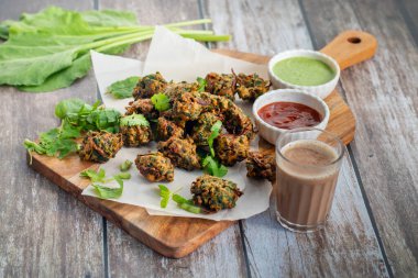 Palak ke pakore gevrek, bol yağda kızartılmış ıspanaklı börek besan, baharat ve taze ıspanak yapraklarıyla yapılır, acılı ve çay ile servis edilir..