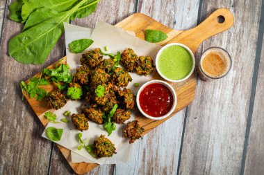 Palak ke pakore gevrek, bol yağda kızartılmış ıspanaklı börek besan, baharat ve taze ıspanak yapraklarıyla yapılır, acılı ve çay ile servis edilir..