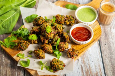 Palak ke pakore gevrek, bol yağda kızartılmış ıspanaklı börek besan, baharat ve taze ıspanak yapraklarıyla yapılır, acılı ve çay ile servis edilir..
