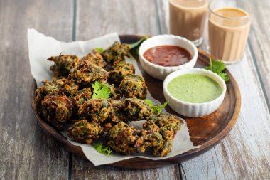 Palak ke pakore gevrek, bol yağda kızartılmış ıspanaklı börek besan, baharat ve taze ıspanak yapraklarıyla yapılır, acılı ve çay ile servis edilir..