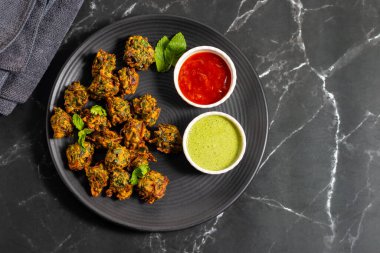 Palak ke pakore gevrek, bol yağda kızartılmış ıspanaklı börek besan, baharat ve taze ıspanak yapraklarıyla yapılır, acılı ve çay ile servis edilir..