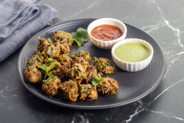 Palak ke pakore gevrek, bol yağda kızartılmış ıspanaklı börek besan, baharat ve taze ıspanak yapraklarıyla yapılır, acılı ve çay ile servis edilir..