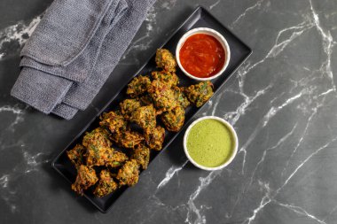 Palak ke pakore gevrek, bol yağda kızartılmış ıspanaklı börek besan, baharat ve taze ıspanak yapraklarıyla yapılır, acılı ve çay ile servis edilir..