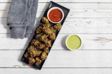 Palak ke pakore gevrek, bol yağda kızartılmış ıspanaklı börek besan, baharat ve taze ıspanak yapraklarıyla yapılır, acılı ve çay ile servis edilir..