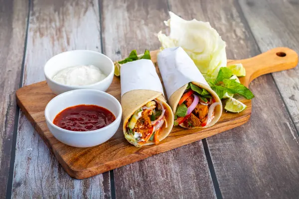 Tavuk shawarma dürümü baharatlı ızgara tavuk, sarımsak sosu, sebze turşusu ve taze ekmek ile yapılan bir Orta Doğu dürümü..