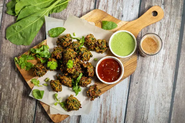 Palak ke pakore gevrek, bol yağda kızartılmış ıspanaklı börek besan, baharat ve taze ıspanak yapraklarıyla yapılır, acılı ve çay ile servis edilir..