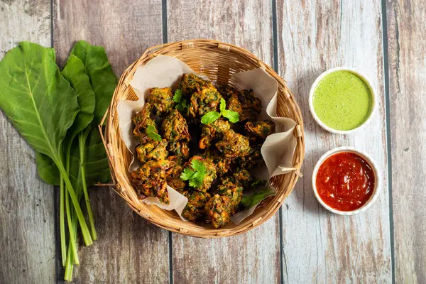 Palak ke pakore gevrek, bol yağda kızartılmış ıspanaklı börek besan, baharat ve taze ıspanak yapraklarıyla yapılır, acılı ve çay ile servis edilir..