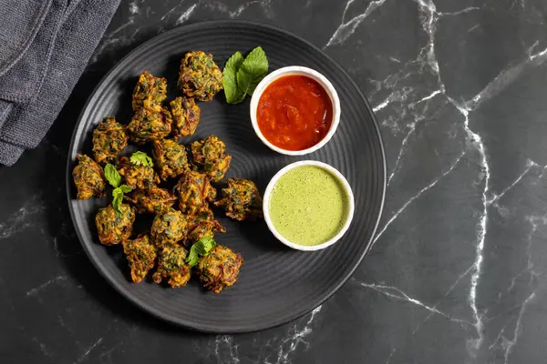 Palak ke pakore gevrek, bol yağda kızartılmış ıspanaklı börek besan, baharat ve taze ıspanak yapraklarıyla yapılır, acılı ve çay ile servis edilir..