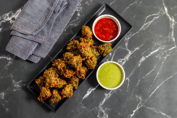 Palak ke pakore gevrek, bol yağda kızartılmış ıspanaklı börek besan, baharat ve taze ıspanak yapraklarıyla yapılır, acılı ve çay ile servis edilir..