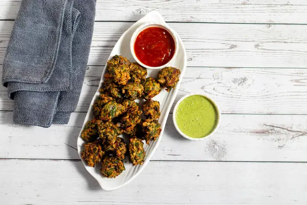 Palak ke pakore gevrek, bol yağda kızartılmış ıspanaklı börek besan, baharat ve taze ıspanak yapraklarıyla yapılır, acılı ve çay ile servis edilir..