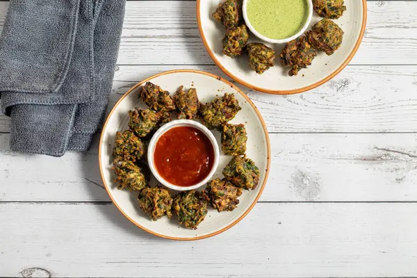 Palak ke pakore gevrek, bol yağda kızartılmış ıspanaklı börek besan, baharat ve taze ıspanak yapraklarıyla yapılır, acılı ve çay ile servis edilir..