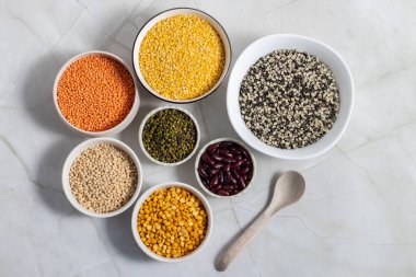 çeşitli Hint mercimek ve fasulyeleri, masoor dal, moong dal, urad dal (derisi ve derisi olmadan), moong bütün, chana dal, ve rajma, mermer bir yüzey üzerinde güzelce dizilmiş kaseler