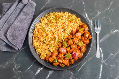 Kızarmış pirinçle servis edilen Soya Mançuryası lezzetli, protein zengini Hint-Çin karışımı baharatlı soya parçaları ve aromatik aromalı sebze pilavı..