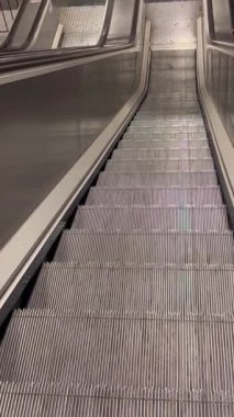 Metro istasyonunun yürüyen merdivenleri dikey görüntülere yaklaşıyor. İnsanların olmadığı boş merdivenler. Yüksek kalite 4k görüntü