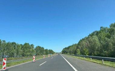 Karayolu manzarası, sol şerit kapalı ve tali yol işaretleri yerleştirilmiş. Yüksek kalite fotoğraf