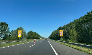 Karayolu manzarası, sol şerit kapalı ve tali yol işaretleri yerleştirilmiş. Yüksek kalite fotoğraf