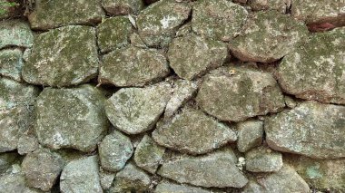 Evin etrafında çitlerle çevrili antik duvar taşları, büyük ve küçük taşlar. Yüksek kalite fotoğraf