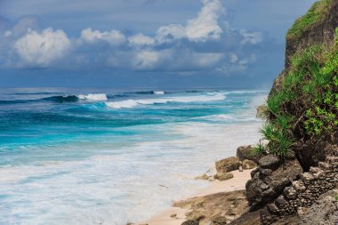 Bali adasında büyük mavi okyanus dalgaları olan tropik bir sahil.