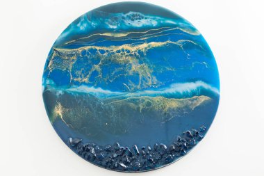 Mavi renkli reçine sanatı ve beyaz arkaplanda taşlar. Epoksi dekorasyon