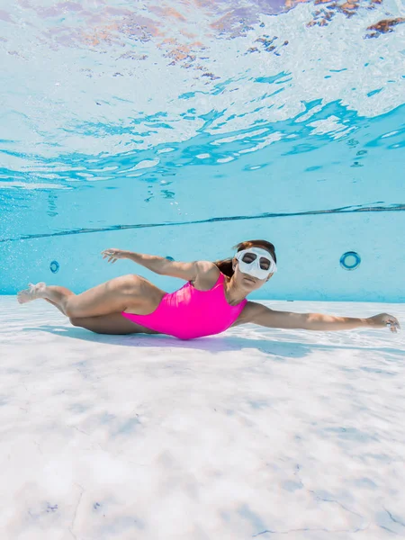 魅力的な女性でピンク水着で水中でプール — ストック写真