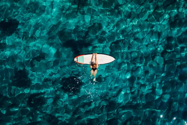 冲浪女孩与冲浪板在透明的蓝绿色海洋中放松 空中俯瞰 — 图库照片