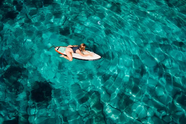 在热带海洋的冲浪板上冲浪的漂亮女人 空中俯瞰 — 图库照片